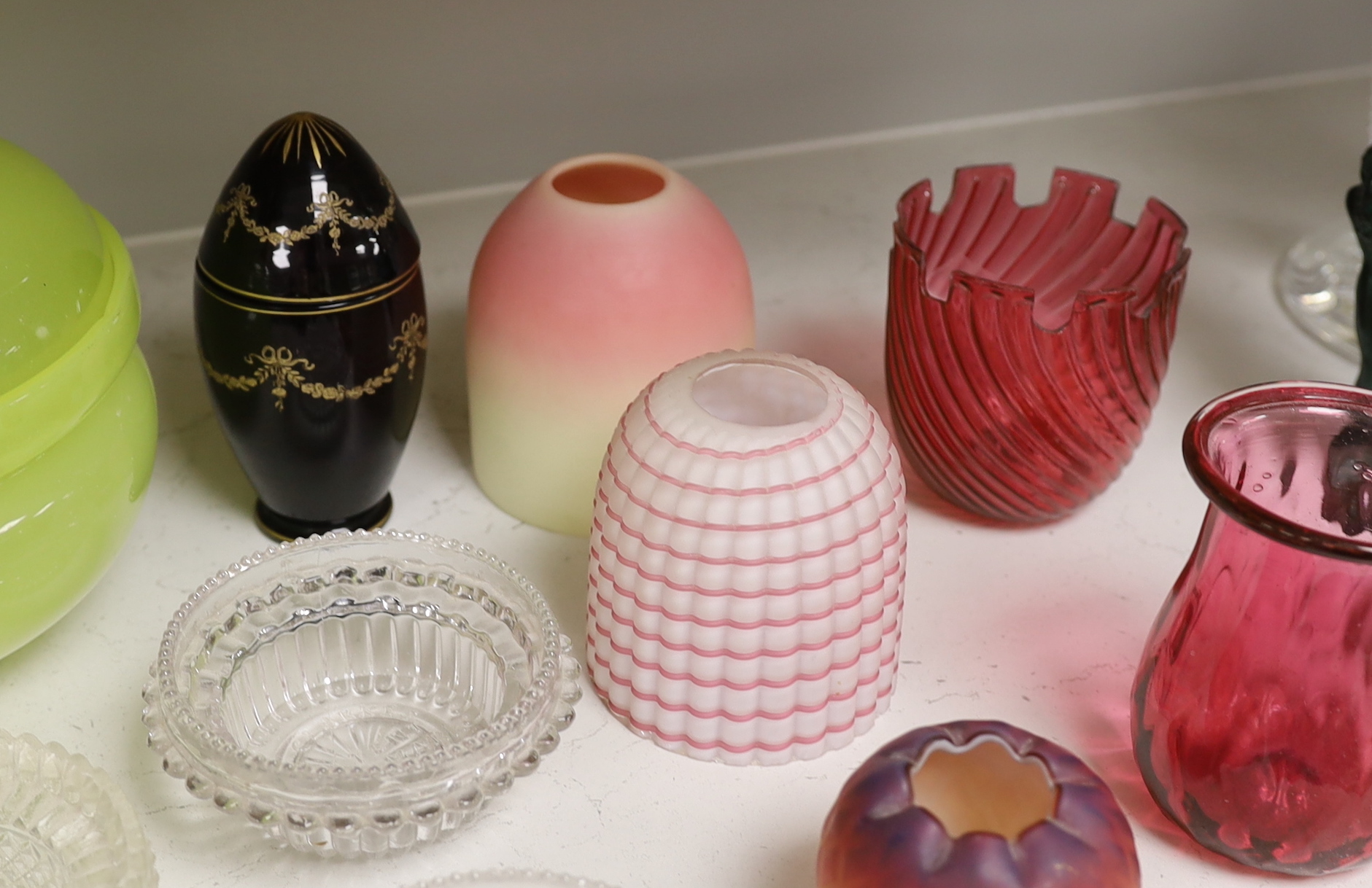 A quantity of various coloured and clear glass including an Art Deco figural scent bottle, cranberry glass vases and a yellow glass jar and cover, largest 30cm high